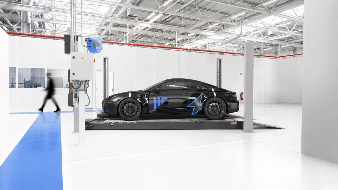 Alpine A110 FUTURE — bok, czarny prototyp na stanowisku pomiarowym w hali testowej