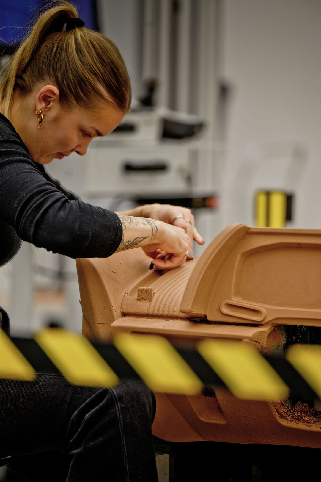 Audi Nuvolari — modelarka ręcznie wygładza gliniany model panelu drzwi w warsztacie projektowym