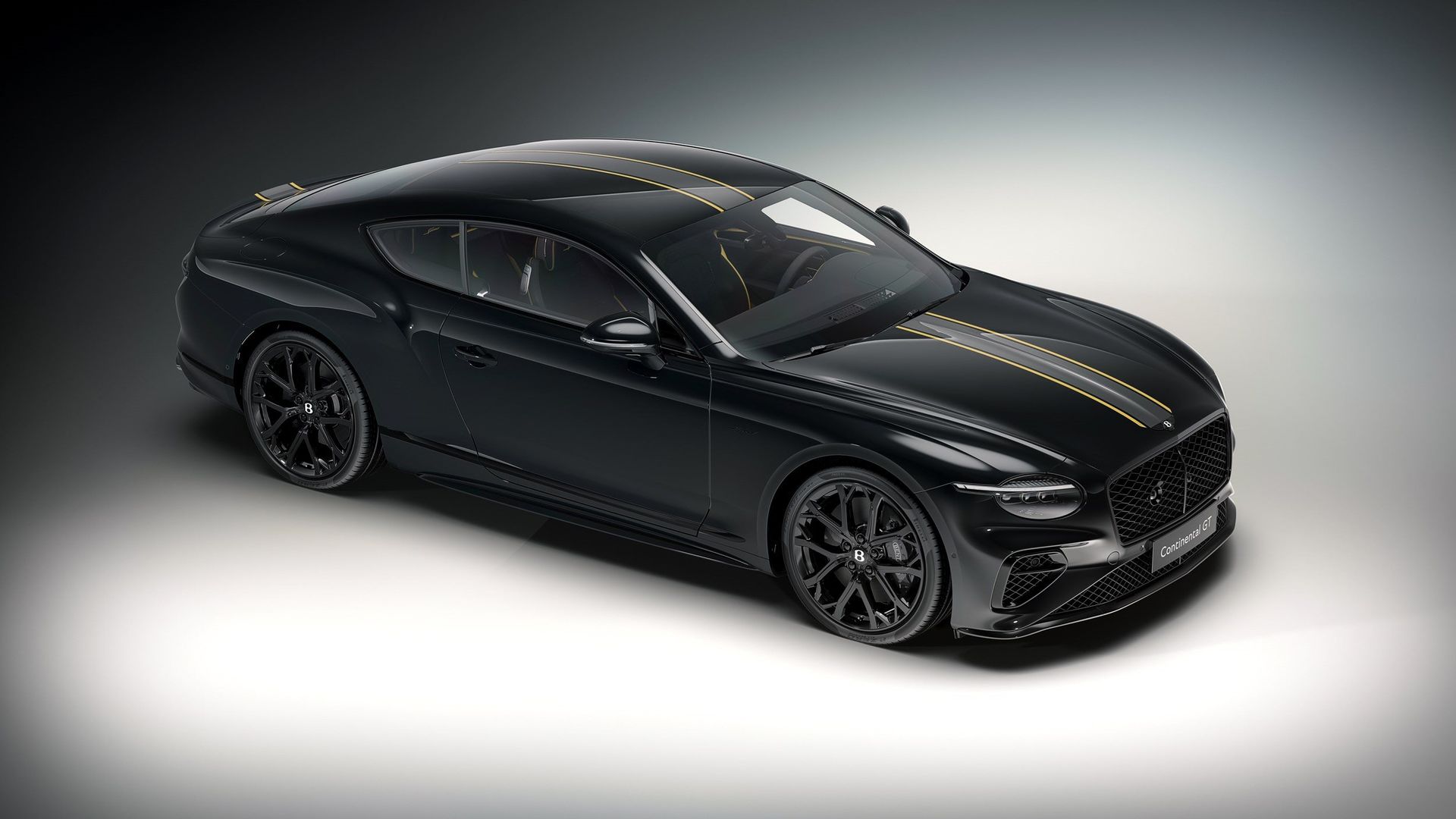 Bentley Continental GT Mulliner — przód i profil 3/4, czarny lakier ze złotymi pasami, studio