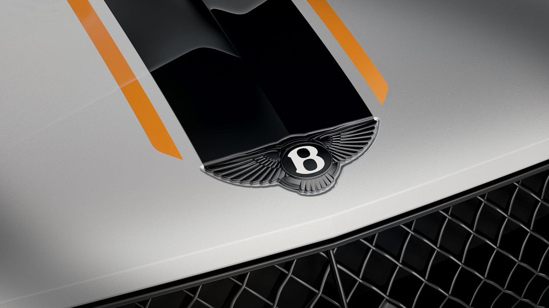 Bentley Mulliner — detal maski, pomarańczowe pasy na srebrnym lakierze, emblemat Bentley