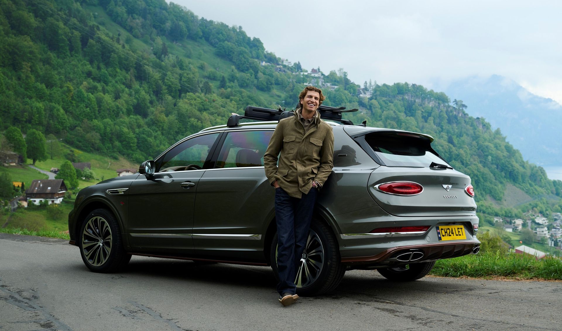 Bentley Bentayga Mulliner — tył, górski krajobraz, mężczyzna obok auta, brytyjska tablica rejestracyjna