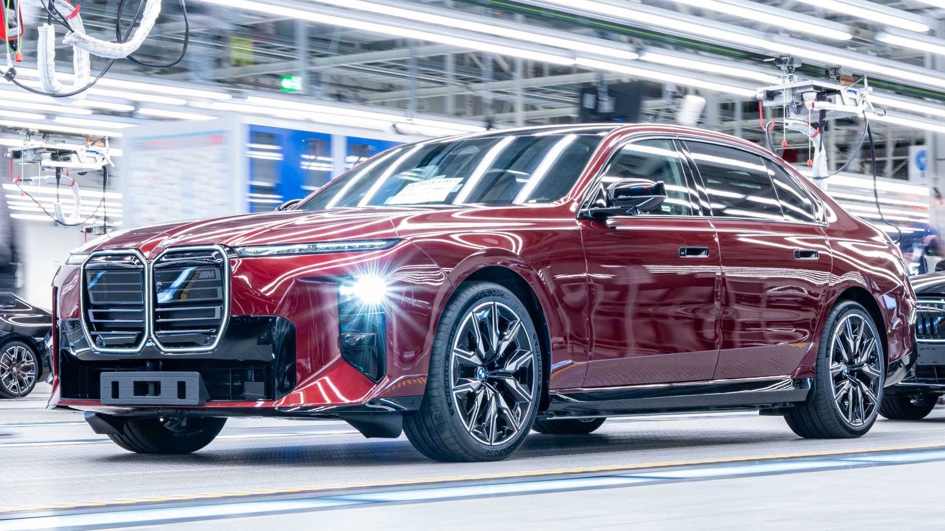 BMW serii 7 — przód i bok, czerwony lakier, na linii produkcyjnej fabryki