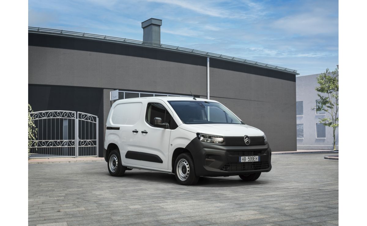 Citroën Berlingo Van First — ujęcie 3/4 z przodu, białe nadwozie, parking przed szarym budynkiem przemysłowym