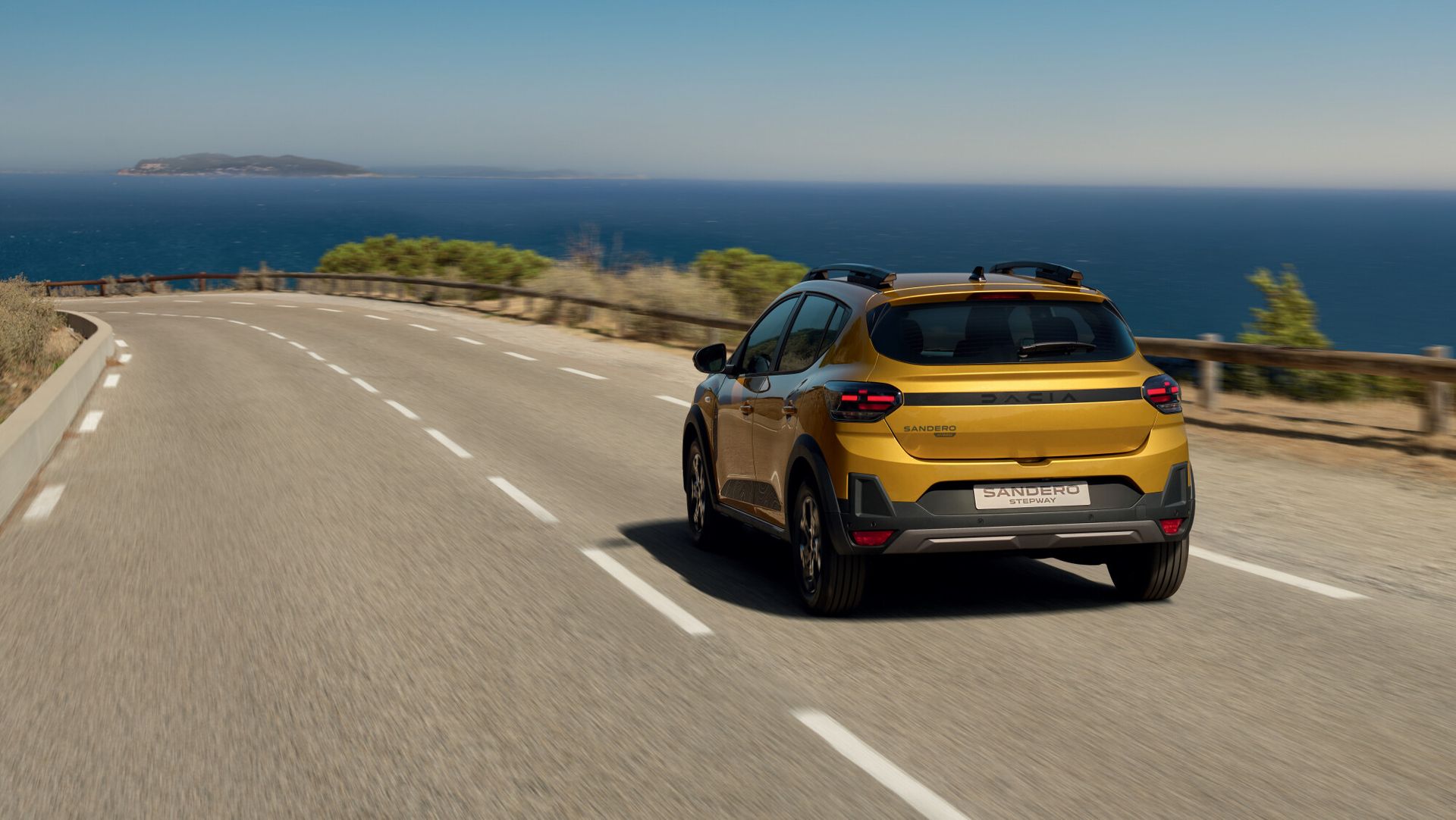 Dacia Sandero Stepway — tył 3/4, dynamiczna jazda nadmorską drogą