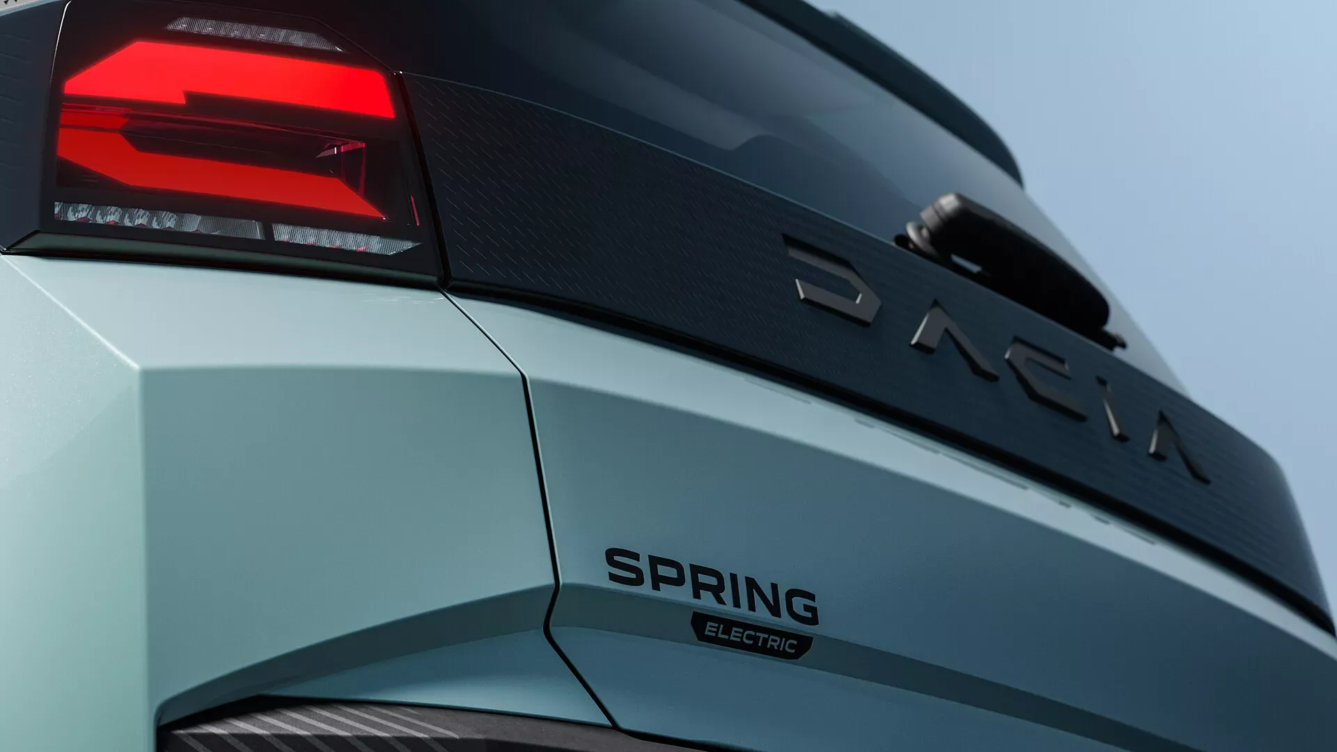Dacia Spring Electric drugiej generacji — detal tylnej lampy LED i napis DACIA na klapie bagażnika, kolor miętowy