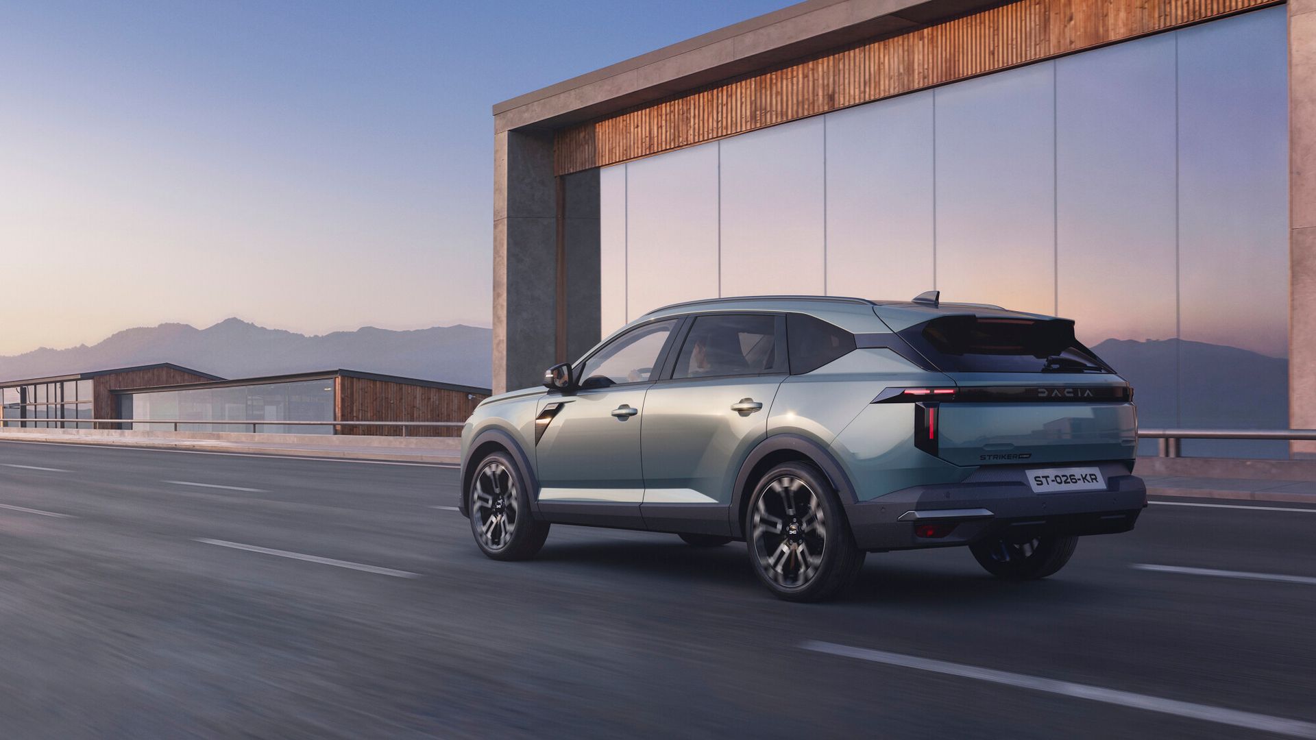 Dacia Striker — tył, jazda przy nowoczesnym szklanym budynku