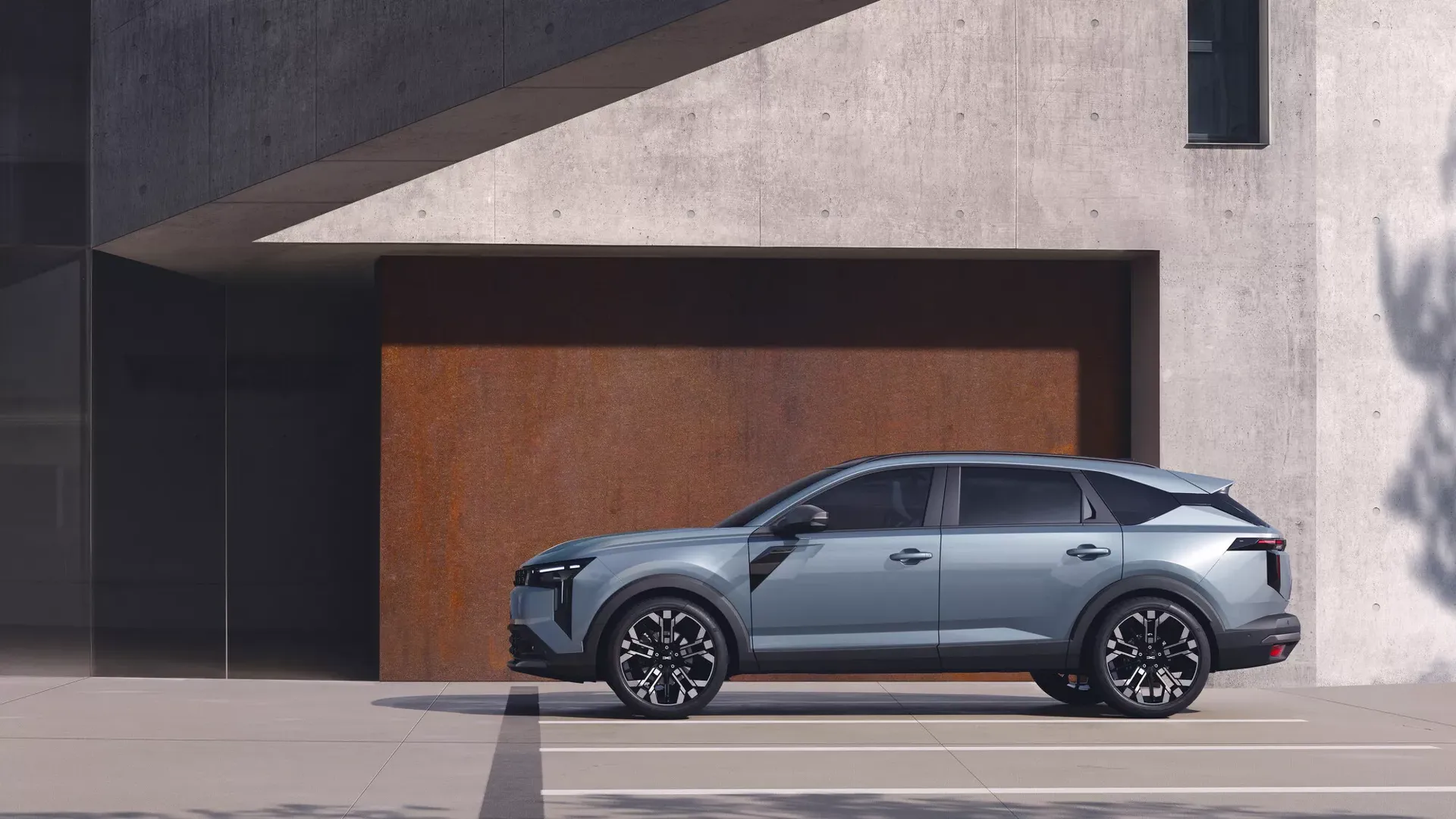 Dacia Striker — bok, postój przy betonowej fasadzie nowoczesnego budynku