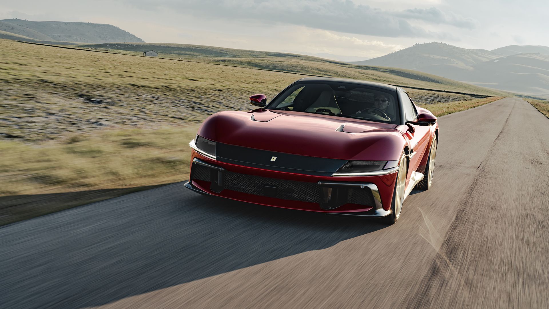 Ferrari 12Cilindri — czerwony, przód 3/4, dynamiczna jazda po górskiej drodze