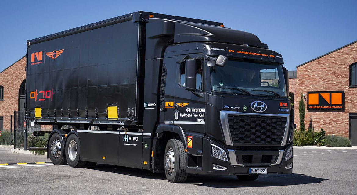 Hyundai Xcient Fuel Cell Genesis Magma Racing — bok, ciężarówka przy stacji tankowania (duplikat ujęcia)
