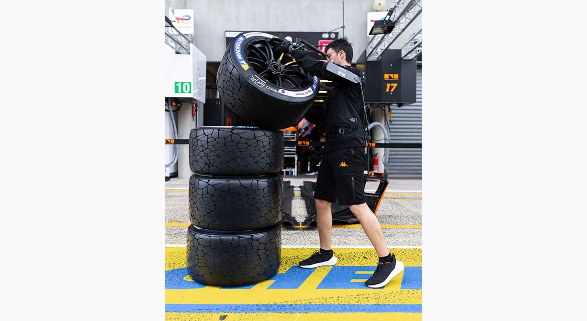 Kulisy Le Mans — mechanik układa opony Michelin w boksie zespołu (duplikat ujęcia)