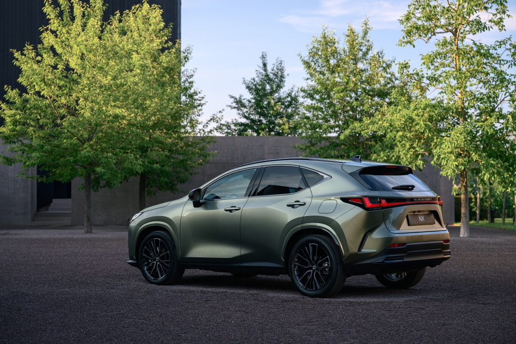 Lexus NX po liftingu — tył 3/4 wśród drzew, scenerii ogrodowej