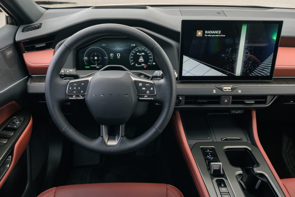 Lexus NX po liftingu — wnętrze, kierownica po lewej stronie i ekran multimedialny, tapicerka w kolorze rdzawym