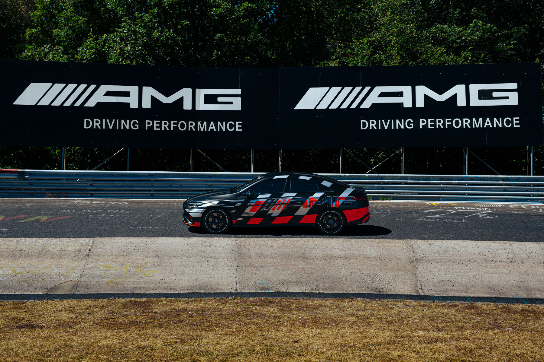 Mercedes-AMG CLA 45 — bok, przejazd pod dwoma banerami AMG Driving Performance