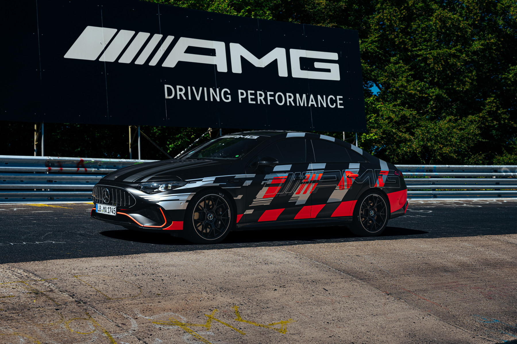 Mercedes-AMG CLA 45 — bok i przód, postój przy banerze AMG Driving Performance