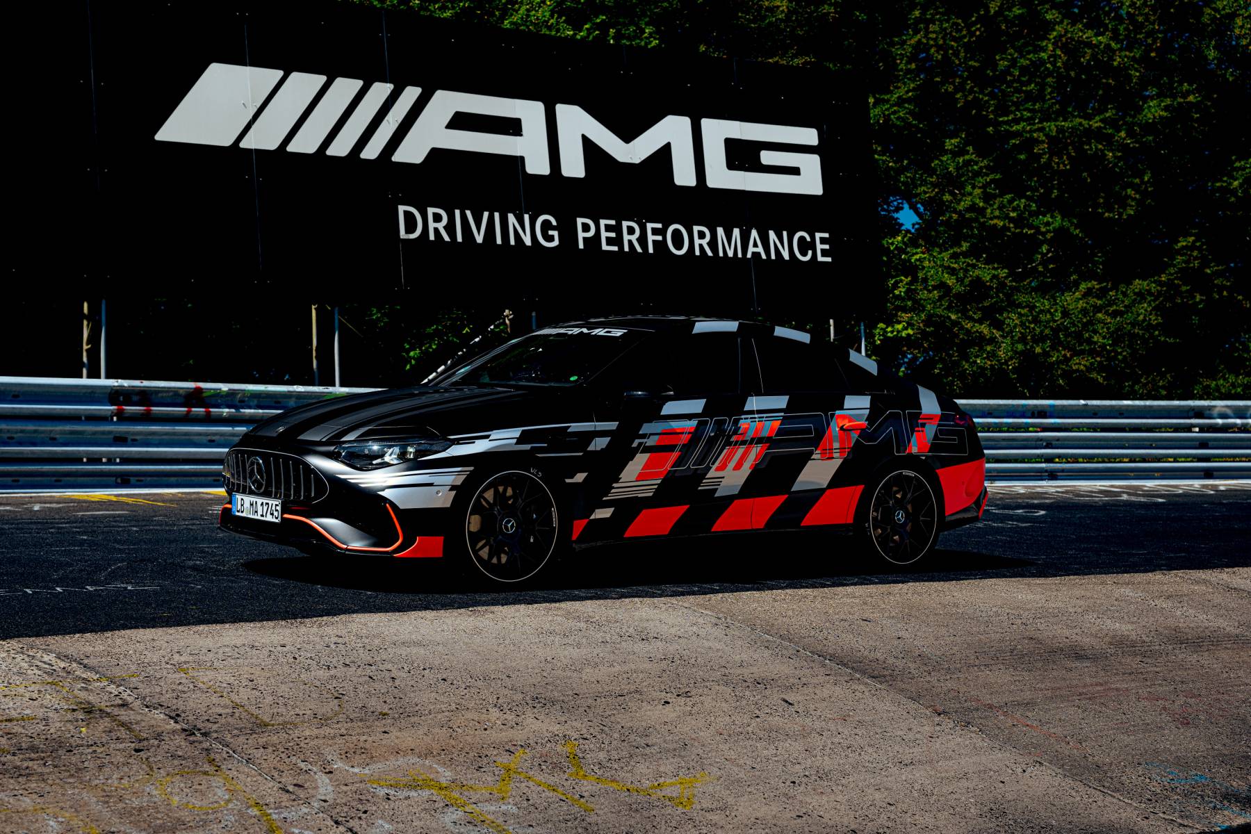 Mercedes-AMG CLA 45 — bok, postój przed billboardem AMG Driving Performance