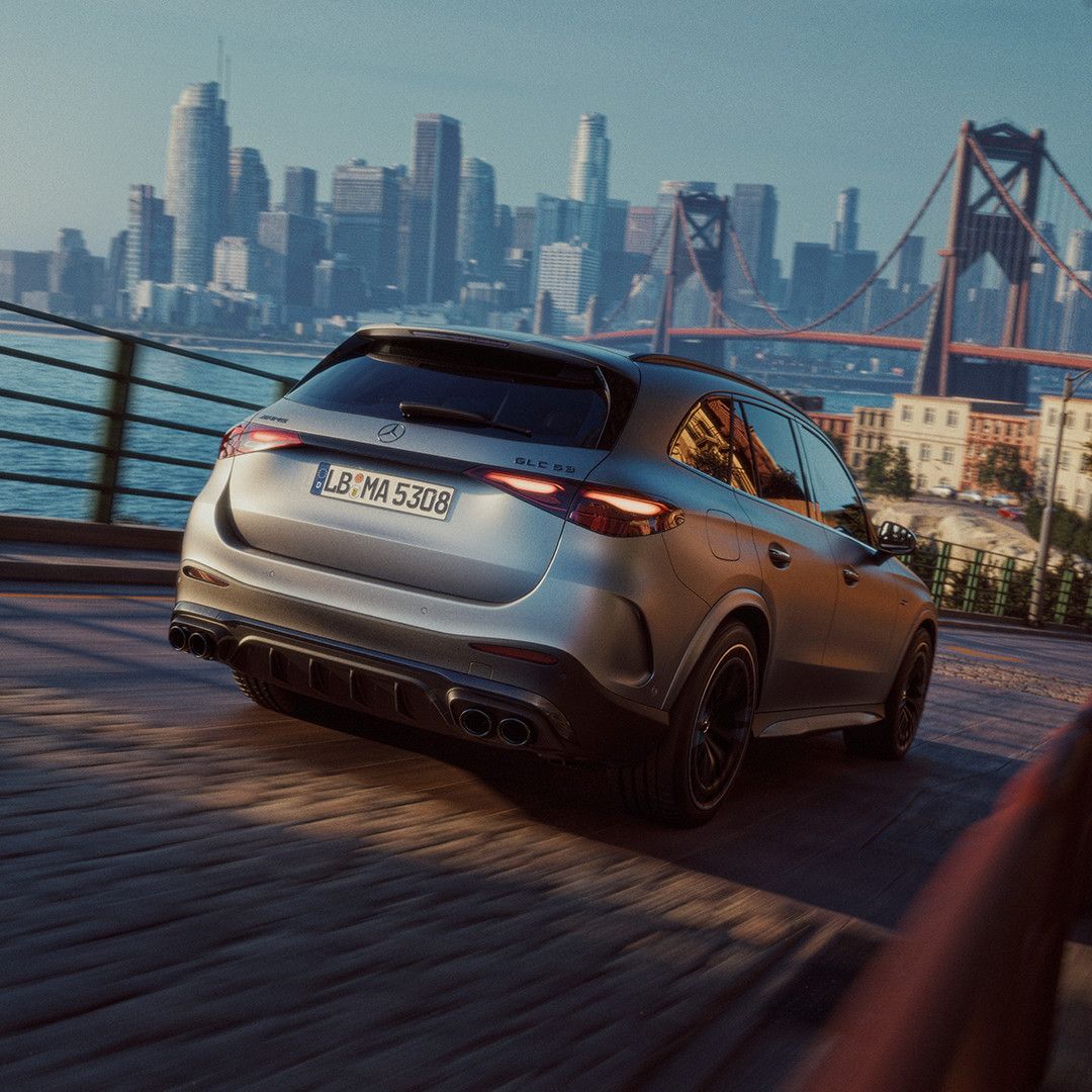 Mercedes-AMG GLC 53 4MATIC+ — tył, jazda na tle mostu i panoramy miasta