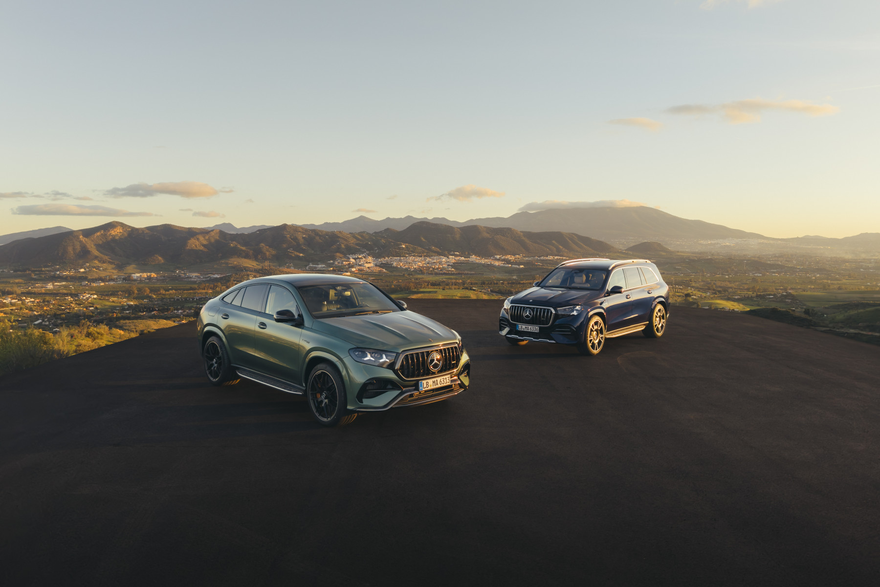 Mercedes-AMG GLE 63 S Coupe i GLS 63 — przód, oba modele o zachodzie słońca na tle gór