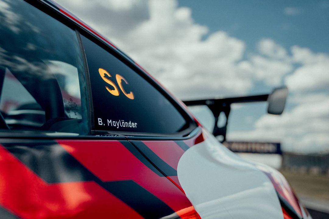 Mercedes-AMG GT 63 PRO – detal naklejki „SC B. Mayländer” na tylnej szybie safety car, w tle rozmyte skrzydło