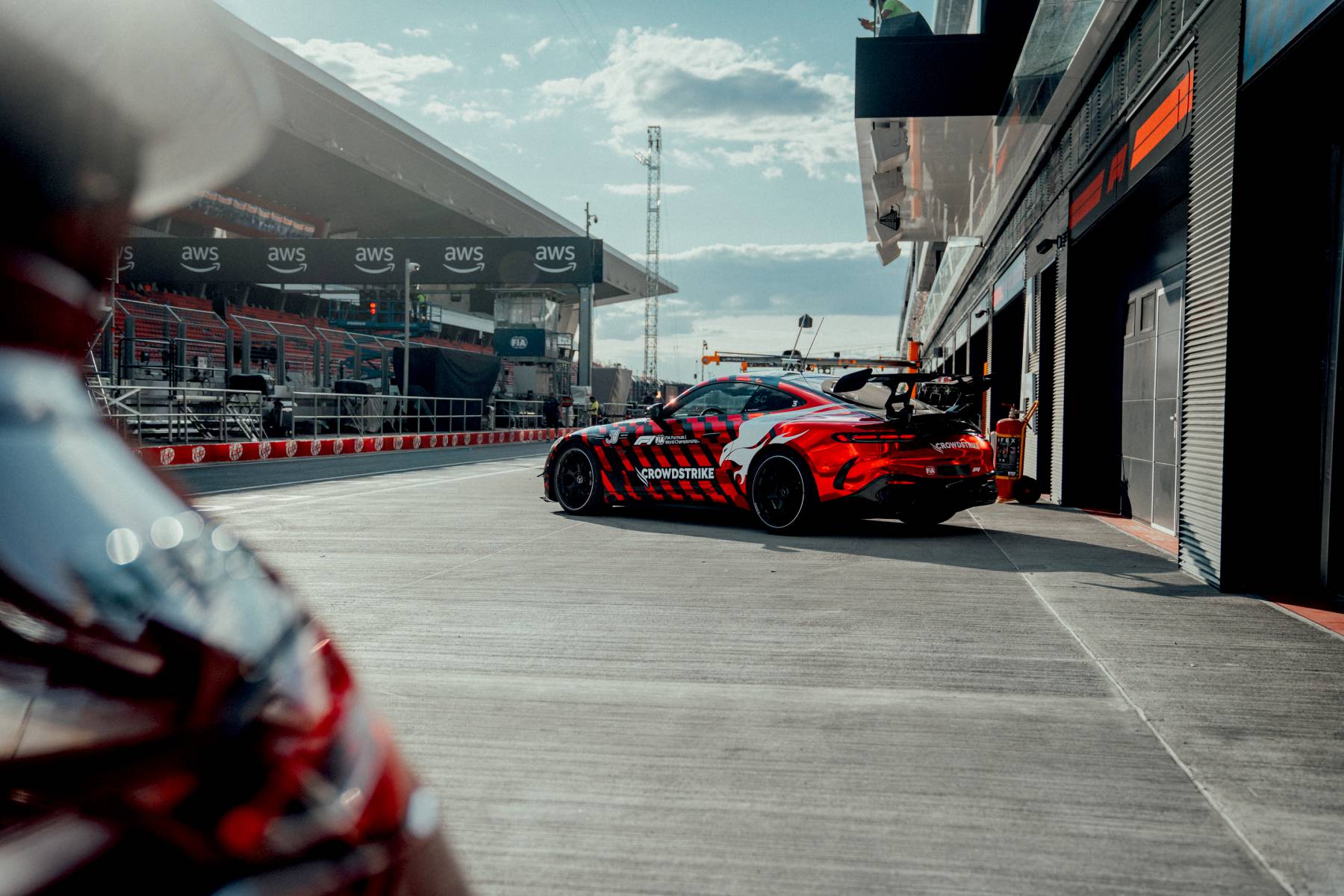 Mercedes-AMG GT 63 PRO – tył safety car w alei serwisowej, ujęcie częściowo zasłonięte rozmytą sylwetką na pierwszym planie