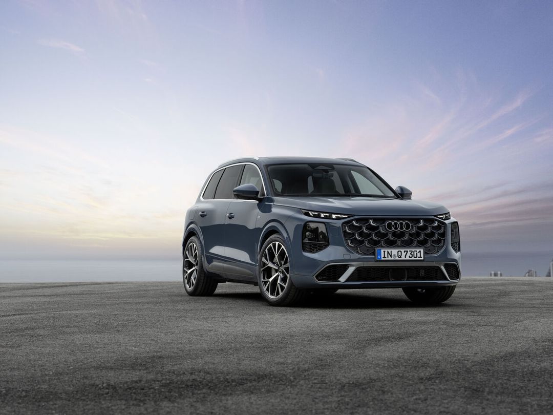 Audi Q7 — przód i bok, ujęcie 3/4 o zachodzie słońca na tle morza