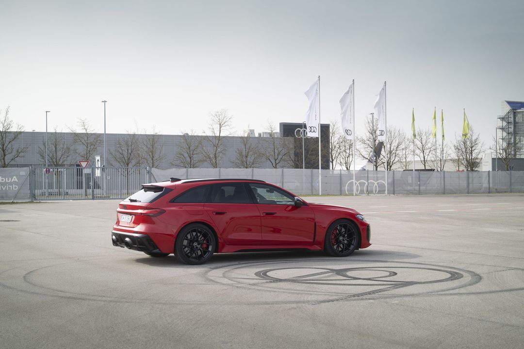 Audi RS 5 — bok i tył, czerwony lakier, jazda testowa na płycie poligonu ze śladami opon