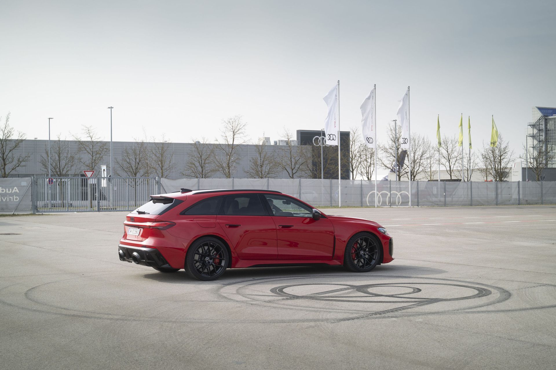 Audi RS 5 — bok i tył, czerwony lakier, jazda testowa na płycie poligonu ze śladami opon