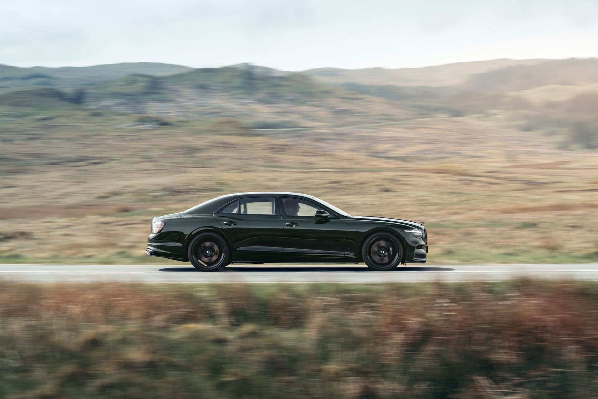 Bentley Flying Spur S — bok, pełny profil w ruchu na tle wzgórz