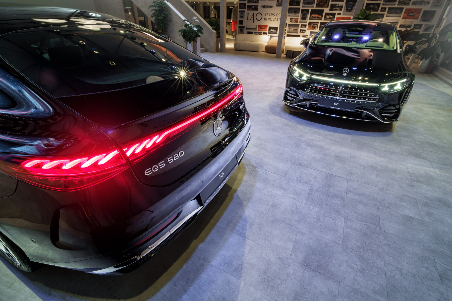 Mercedes-Benz EQS — zbliżenie na tylną lampę, w tle drugi egzemplarz od przodu