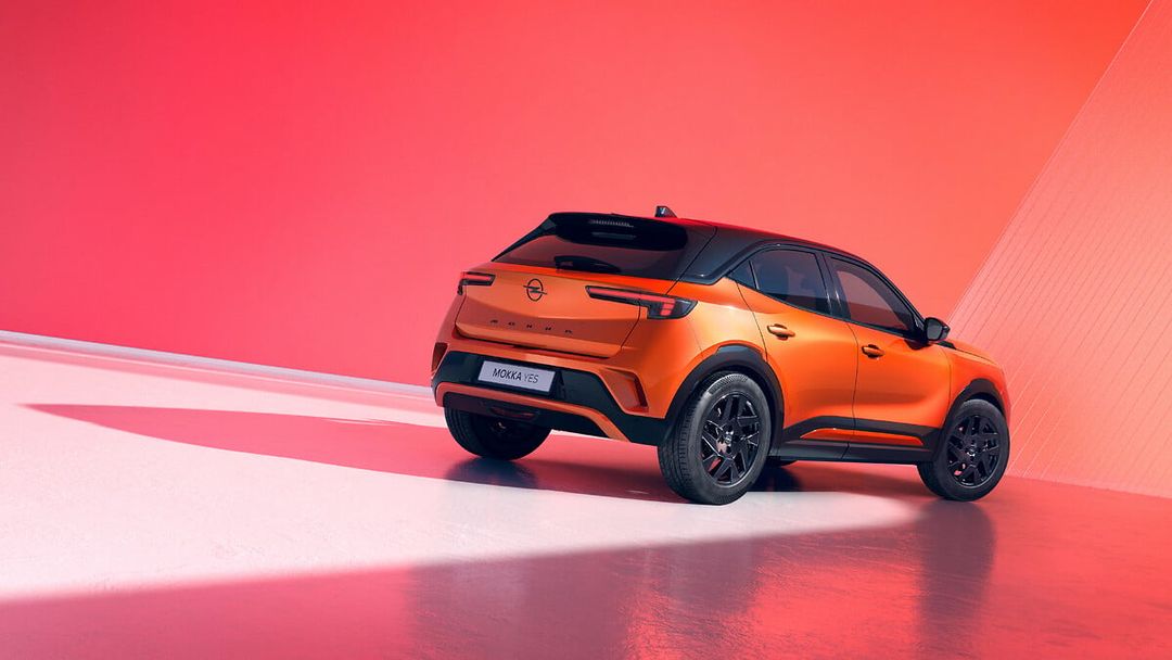 Opel Mokka YES — tył pojazdu, czarno-pomarańczowe nadwozie, tło czerwone