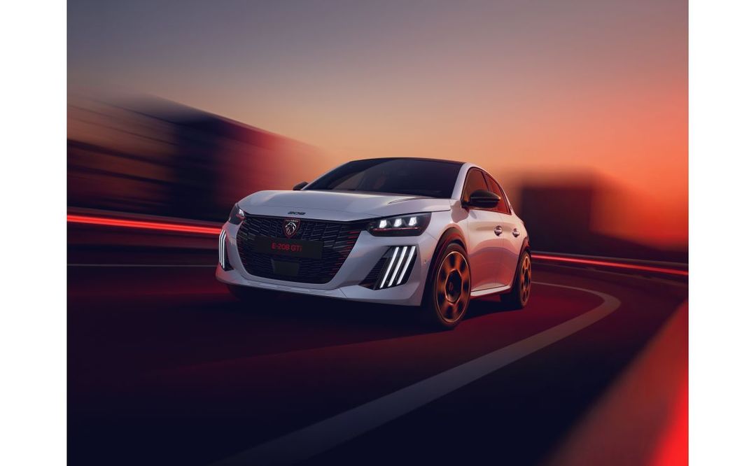 Peugeot E-208 GTi — przód, dynamiczna jazda o zmierzchu ze smugami świateł