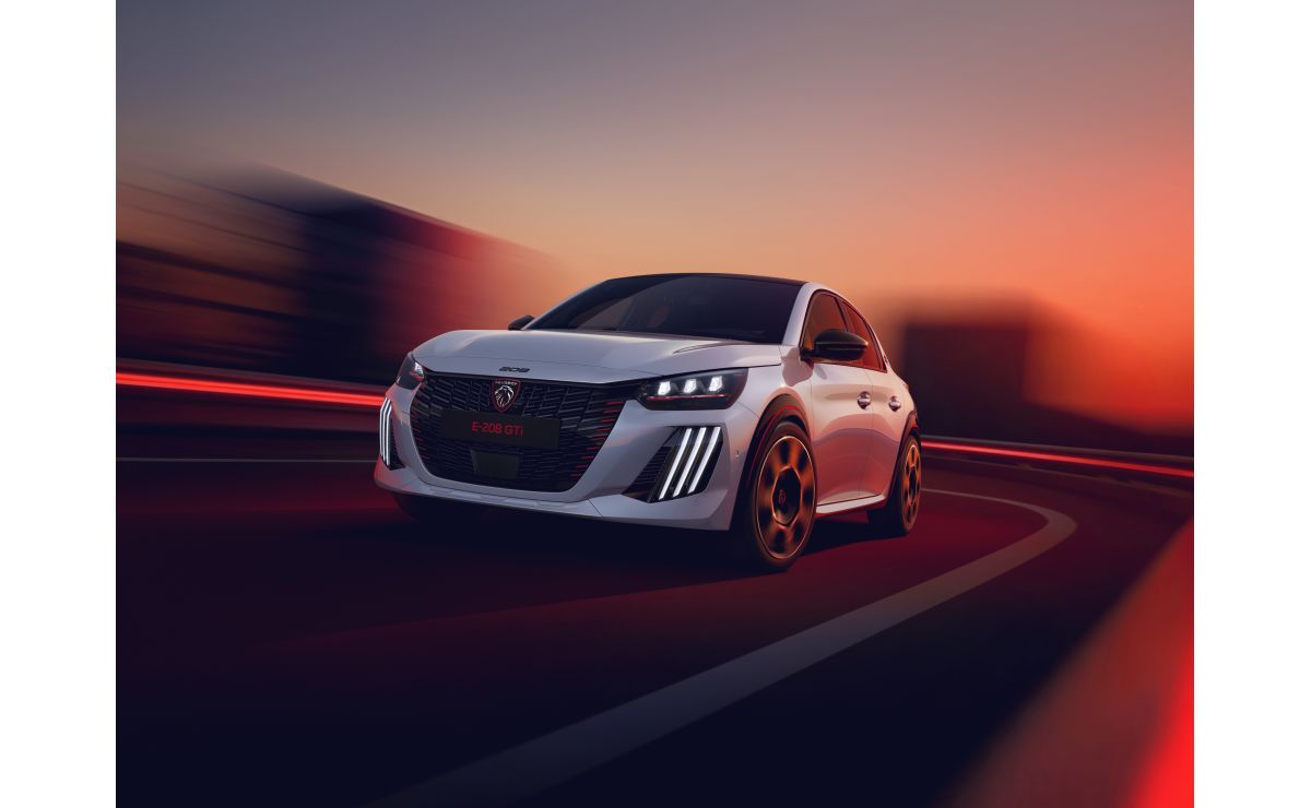Peugeot E-208 GTi — przód, dynamiczna jazda o zmierzchu ze smugami świateł