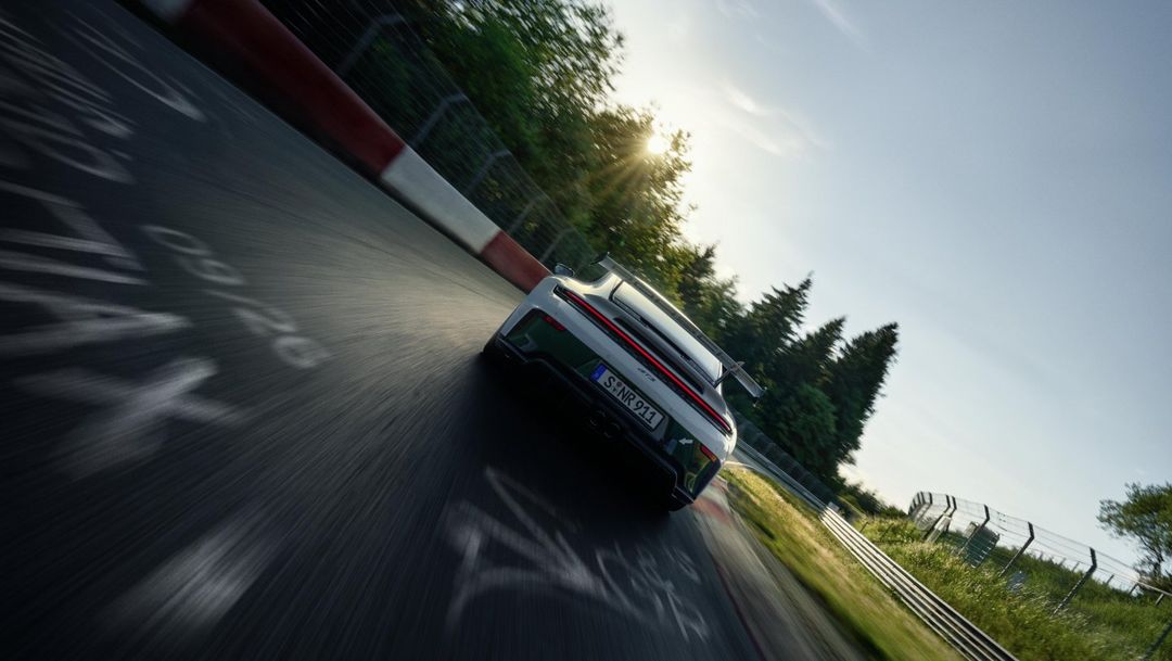 Porsche 911 GT3 — tył z góry, wejście w zakręt na Nürburgring o zachodzie słońca