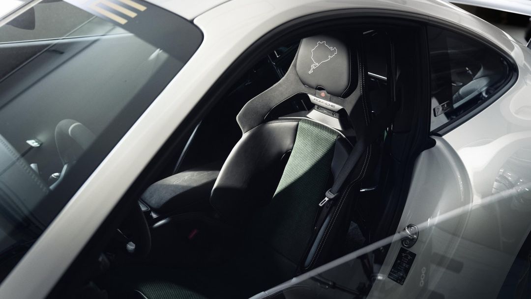 Porsche 911 GT3 — wnętrze, fotel kubełkowy z pasami i logo Nürburgringu na zagłówku