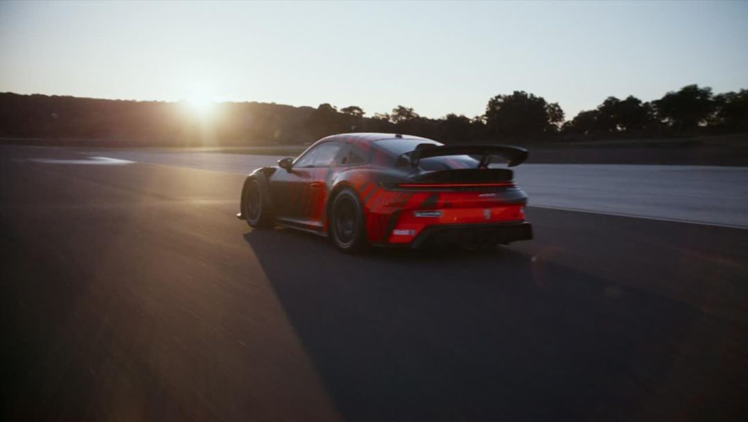 Porsche 911 GT4 R — tył, jazda po torze o zachodzie słońca