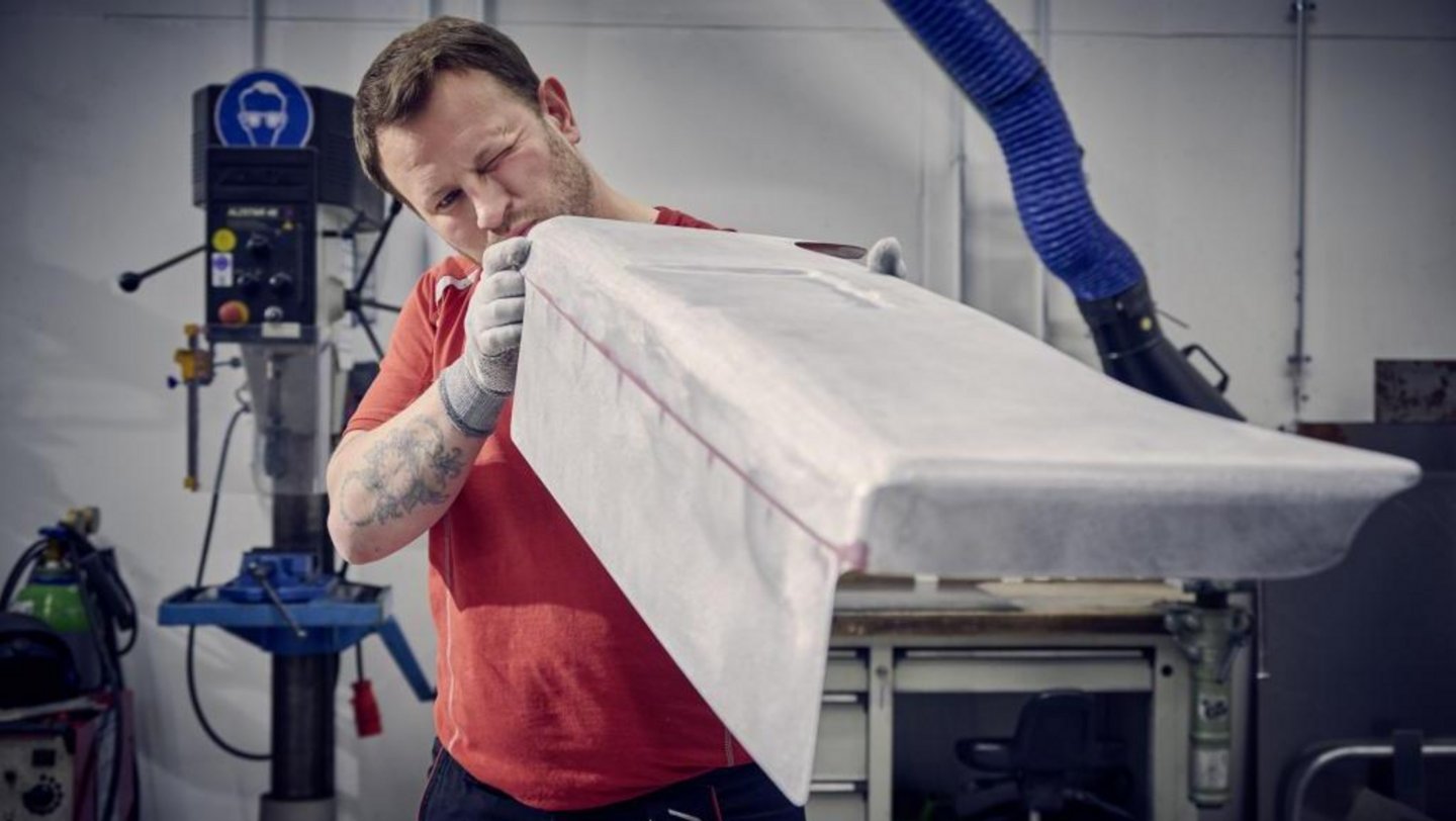 Rzemieślnik Porsche ręcznie wykańcza karbonowy spoiler modelu Flachbau RS