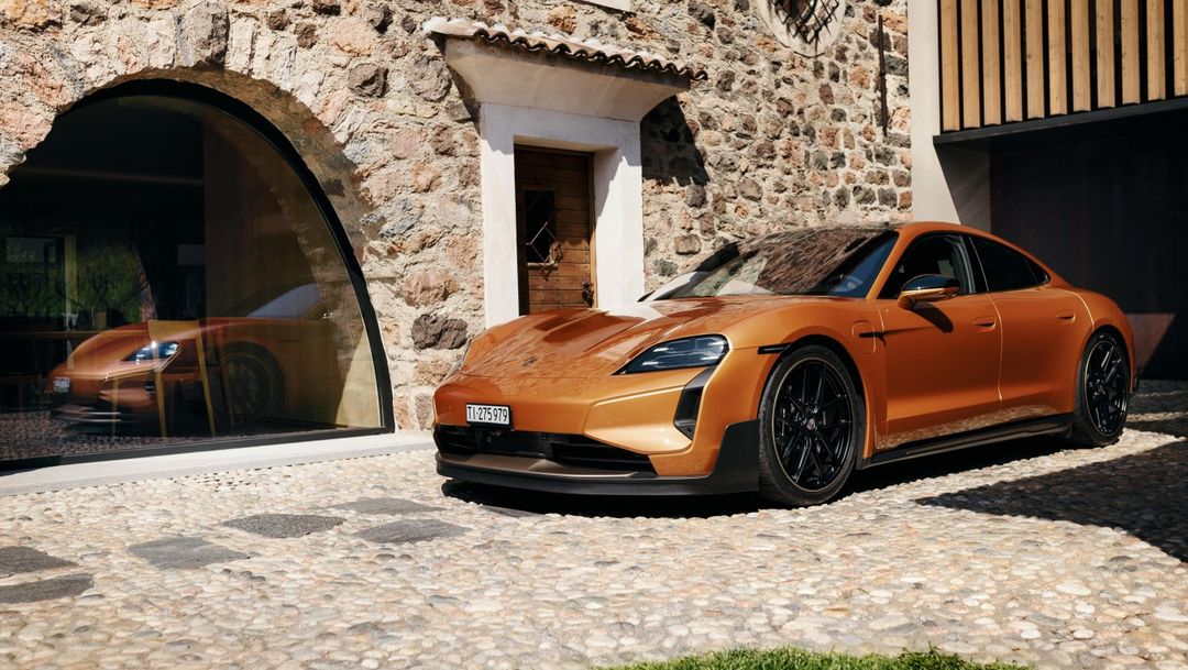 Porsche Taycan Turbo GT — dynamiczny przód 3/4 przy kamiennym łuku willi