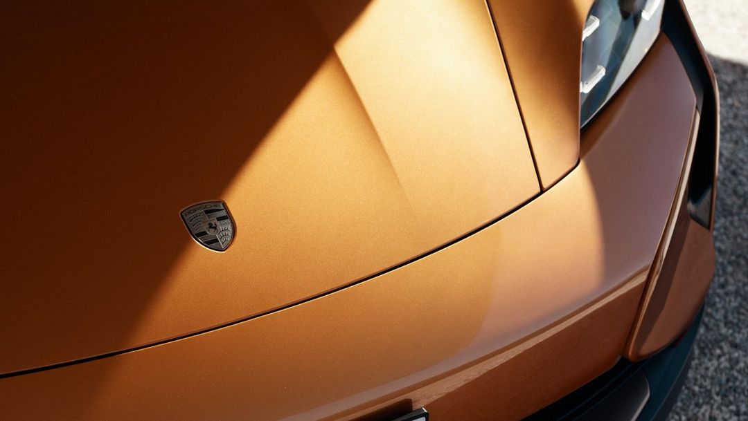 Porsche Taycan Turbo GT — detal maski z logo Porsche w kolorze pomarańczowym