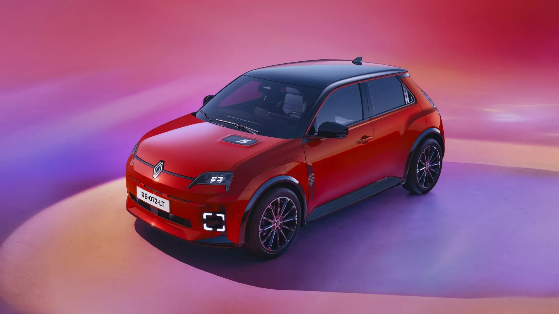 Renault 5 E-Tech — czerwony hatchback, dynamiczne ujęcie przód/bok w studiu