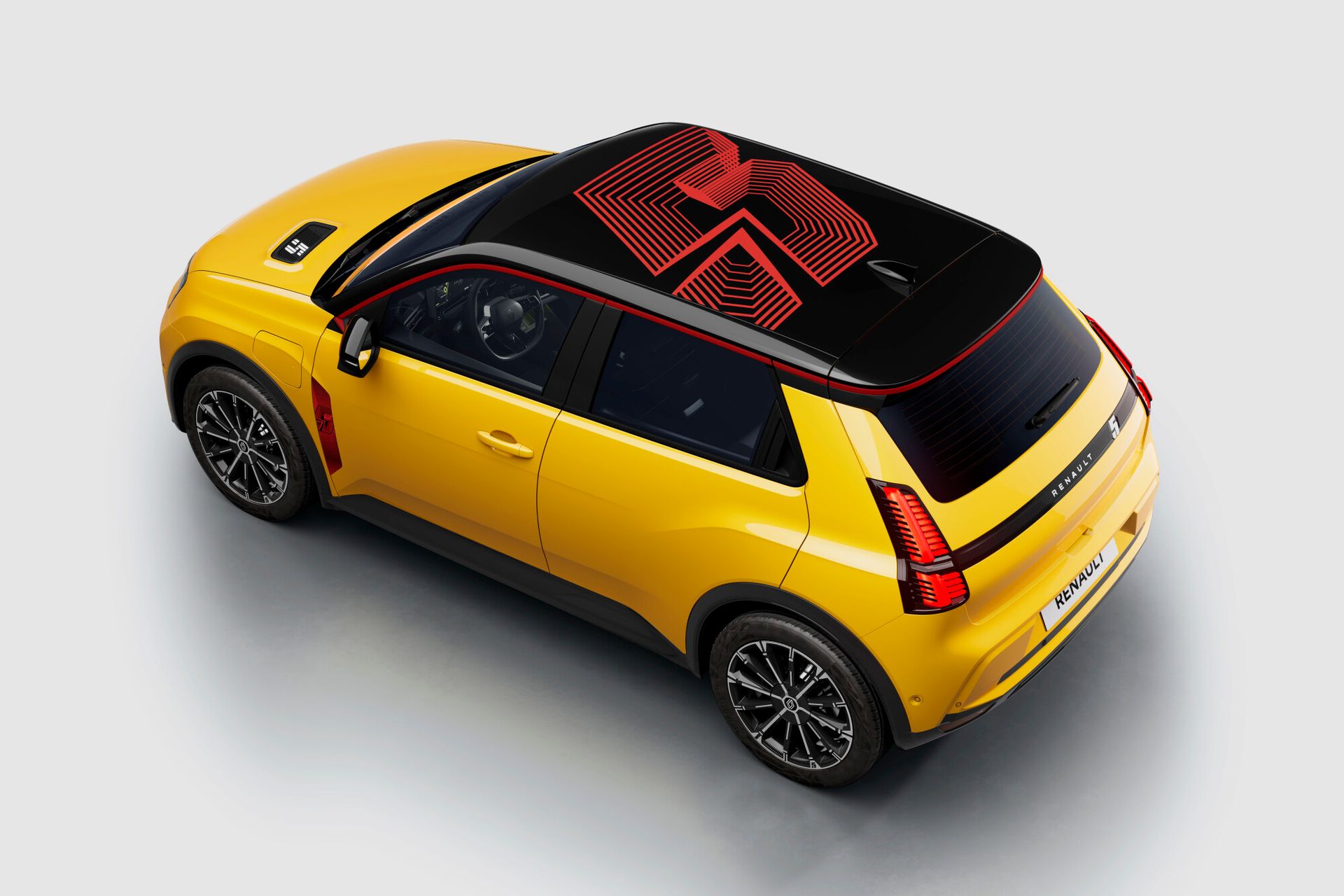 Renault 5 E-Tech — żółty hatchback, widok z góry na tył i dach z grafiką numberR5, ujęcie bliźniacze