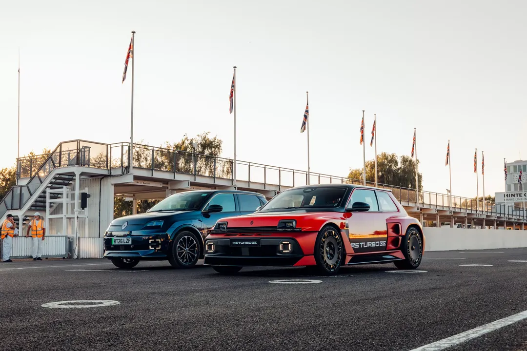 Renault 5 Turbo 3E (czerwony) obok innego modelu Renault — przód, brytyjskie flagi w tle na torze Goodwood