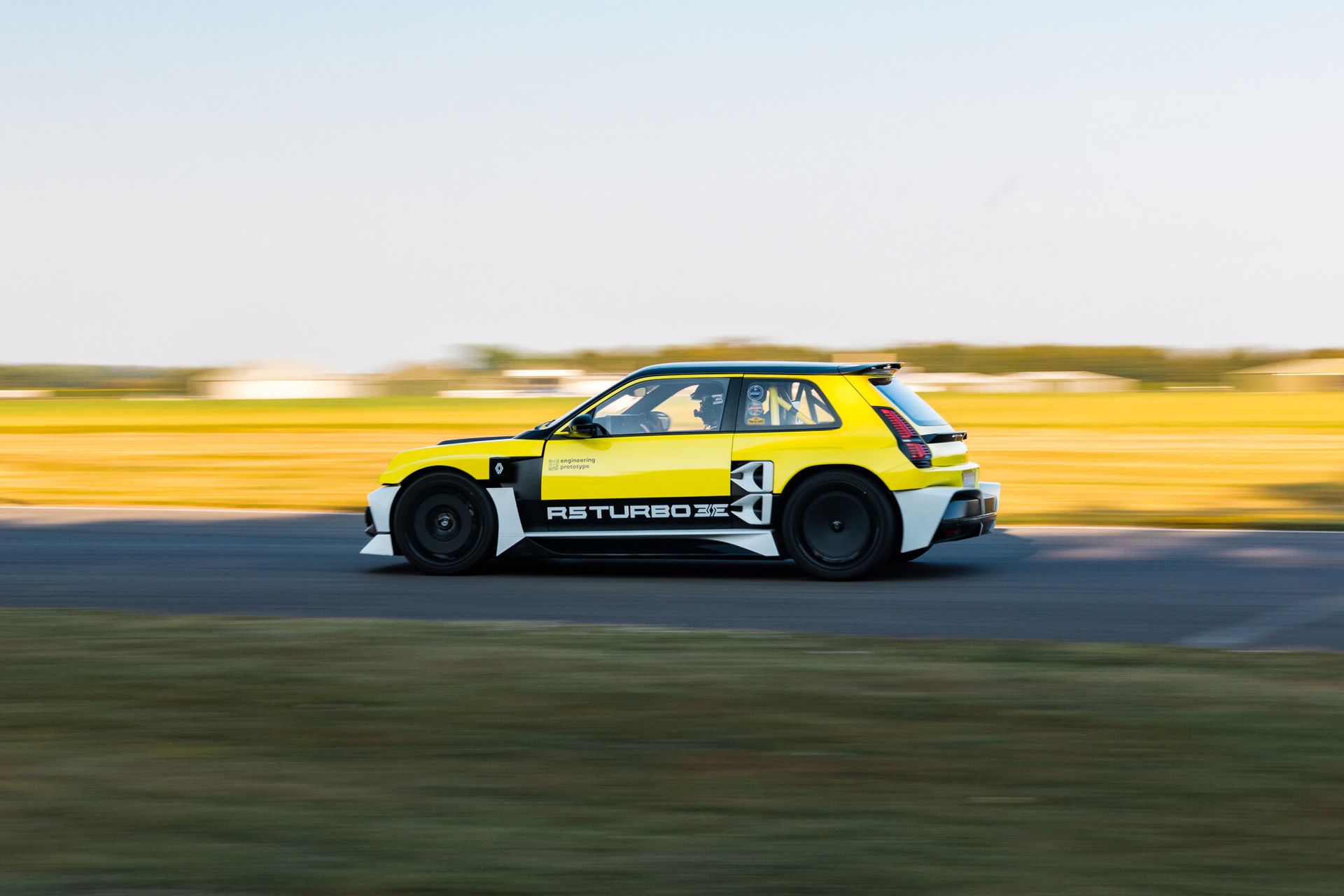 Renault 5 Turbo 3E — żółty egzemplarz, bok, jazda z dużą prędkością po torze