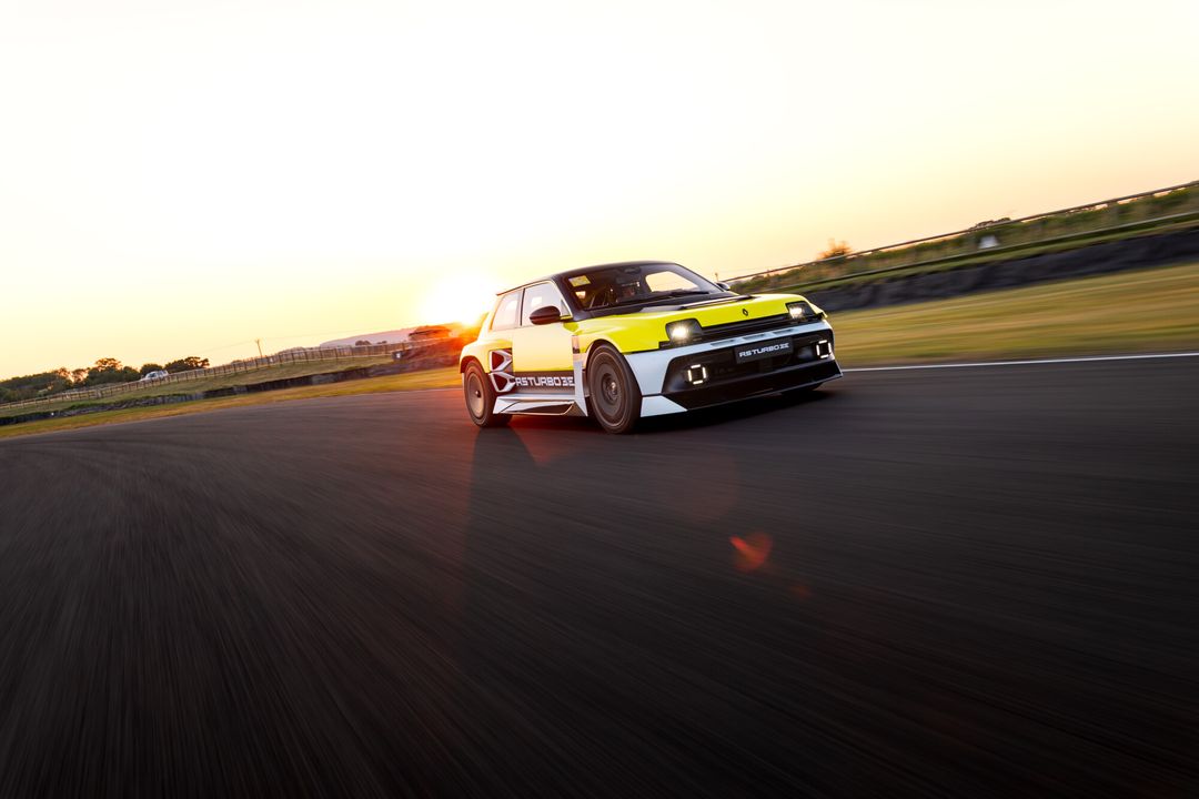 Renault 5 Turbo 3E — żółty egzemplarz, przód 3/4, dynamiczny przejazd o zachodzie słońca