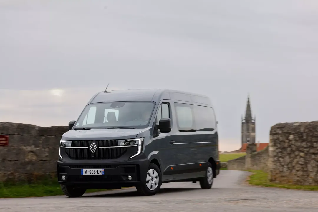 Renault Master (furgon, kolor szary) — przód, postój przy murze z wieżą kościoła w tle