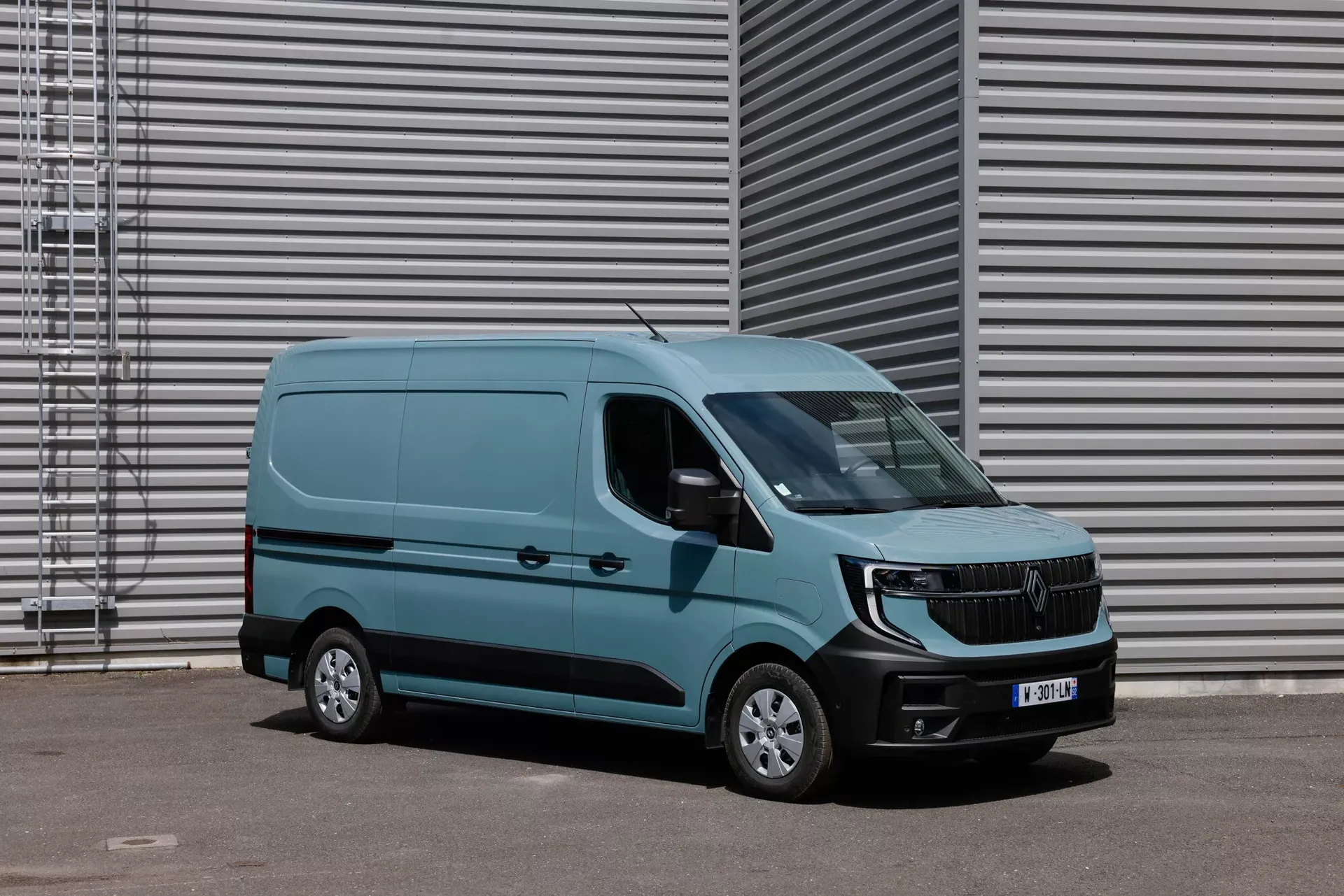 Renault Master (furgon, kolor błękitny) — przód, postój przy hali z blachy falistej