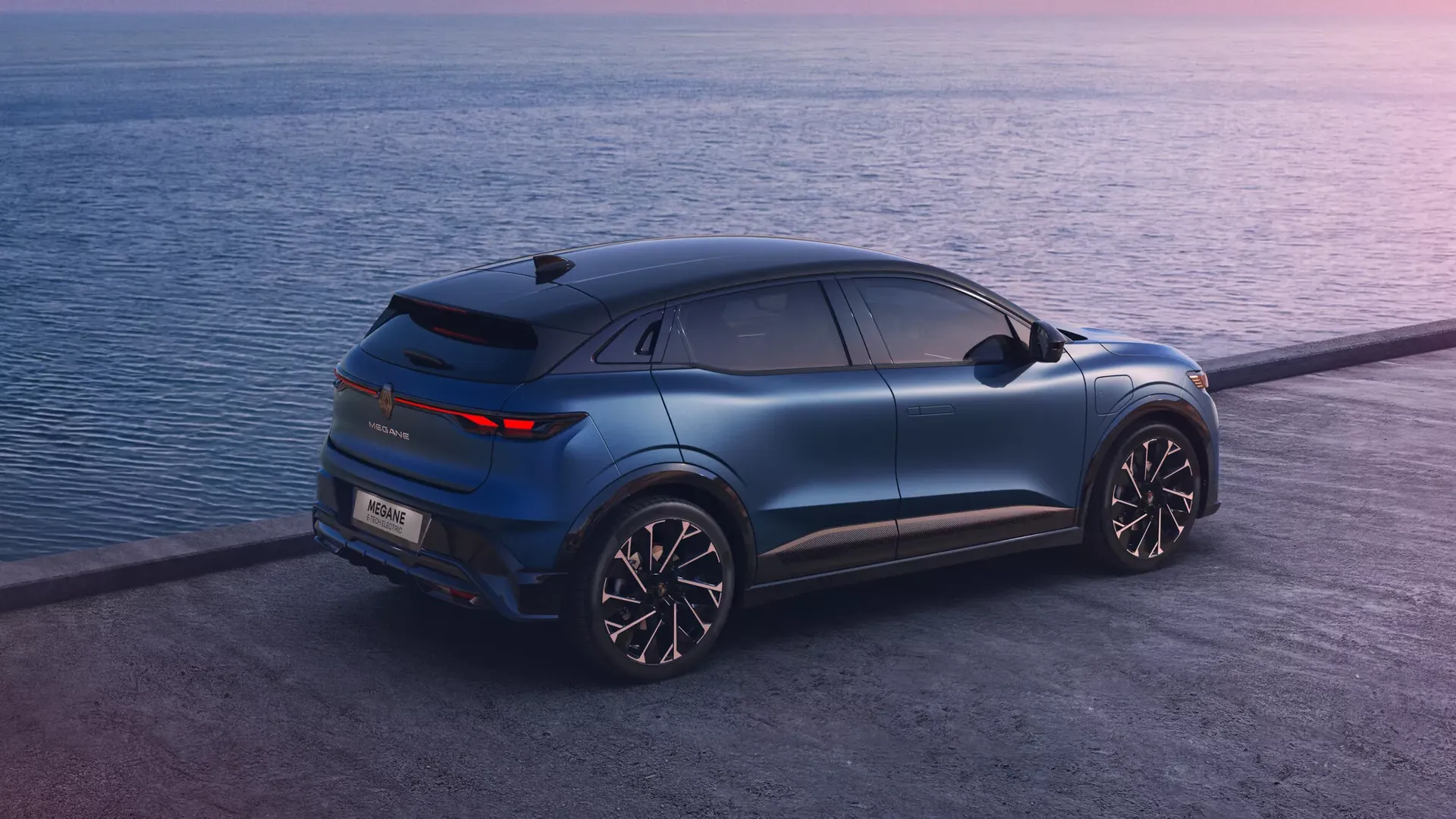 Renault Megane E-Tech Electric — tył/bok, zaparkowany na nabrzeżu nad morzem o zmierzchu