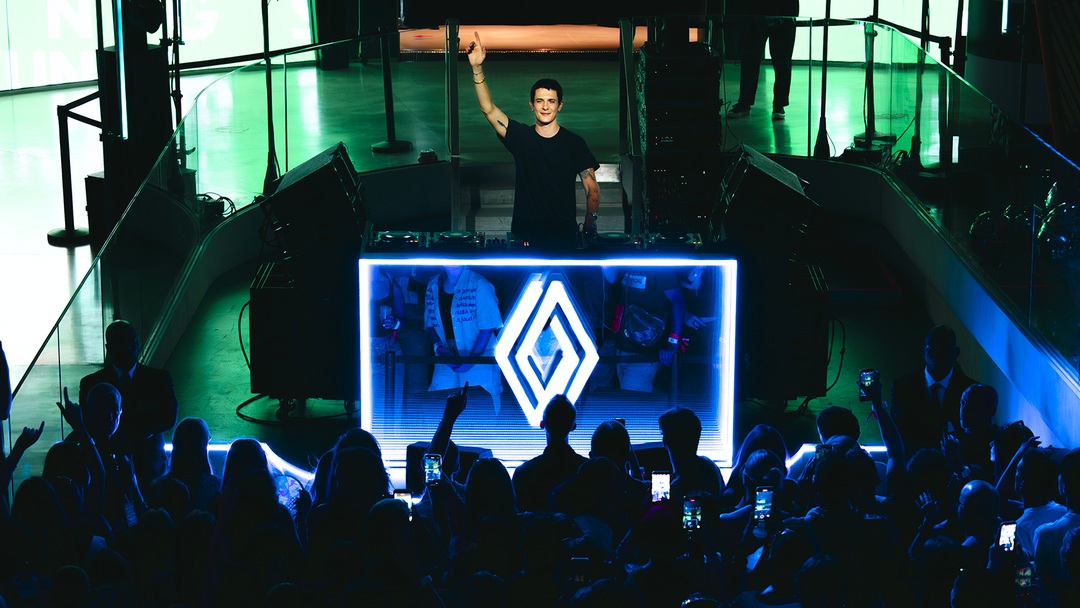 Renault — impreza Twingo Live Show, DJ z uniesioną ręką i tłum publiczności w klubowym, niebieskim oświetleniu