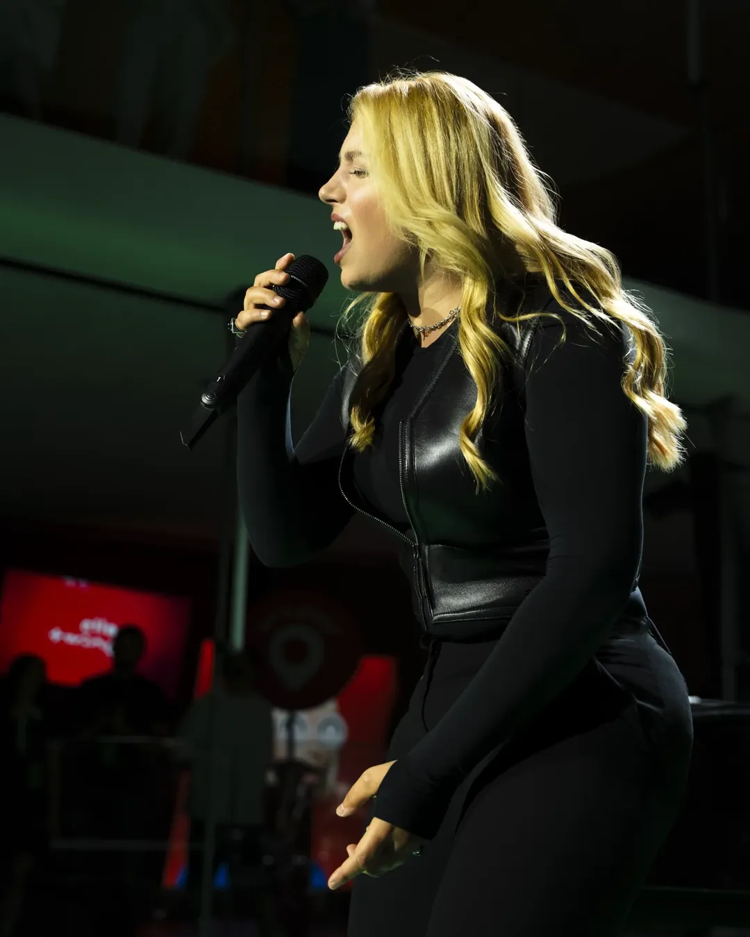 Renault — blond wokalistka śpiewająca profilem do mikrofonu na scenie Twingo Live Show