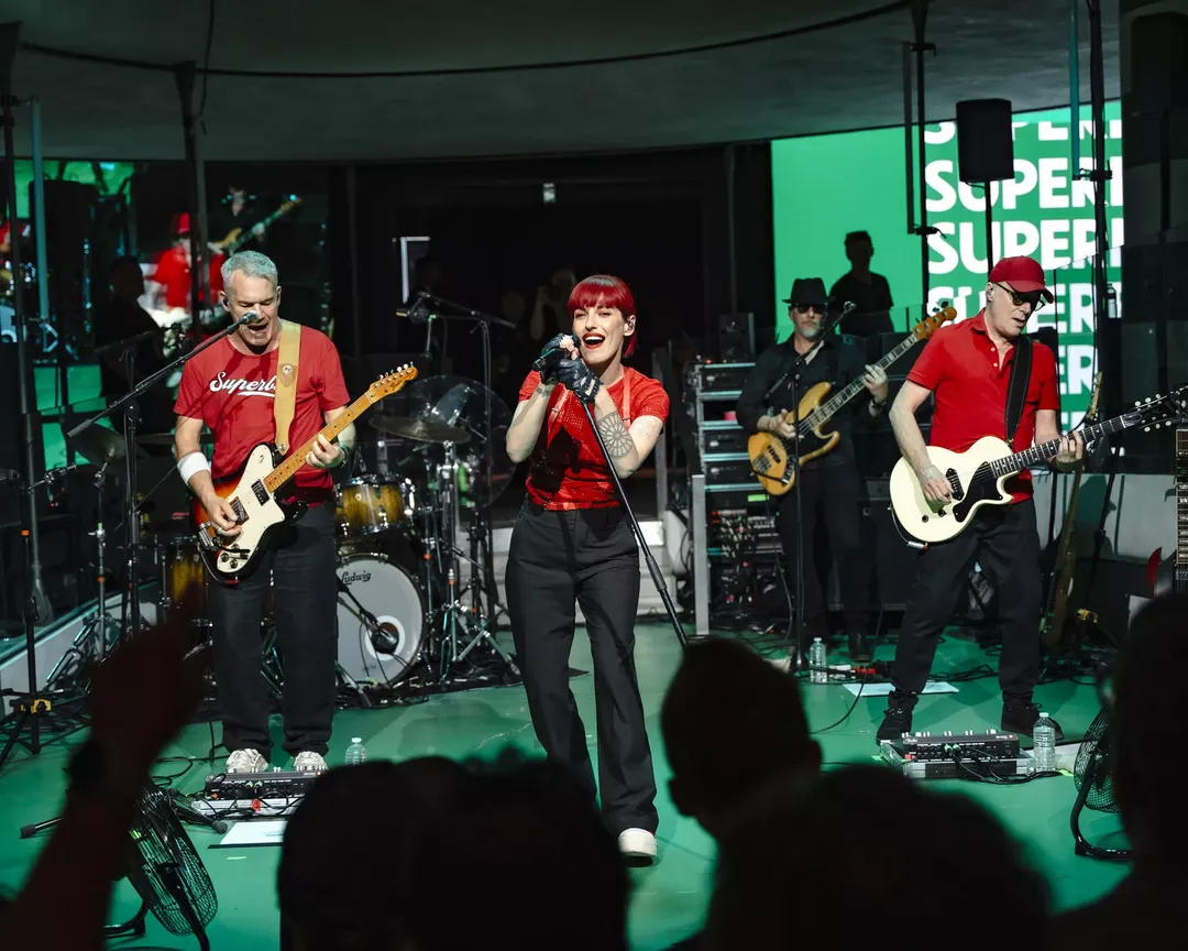Renault — zespół muzyczny w czerwonych koszulkach grający na gitarach przed publicznością