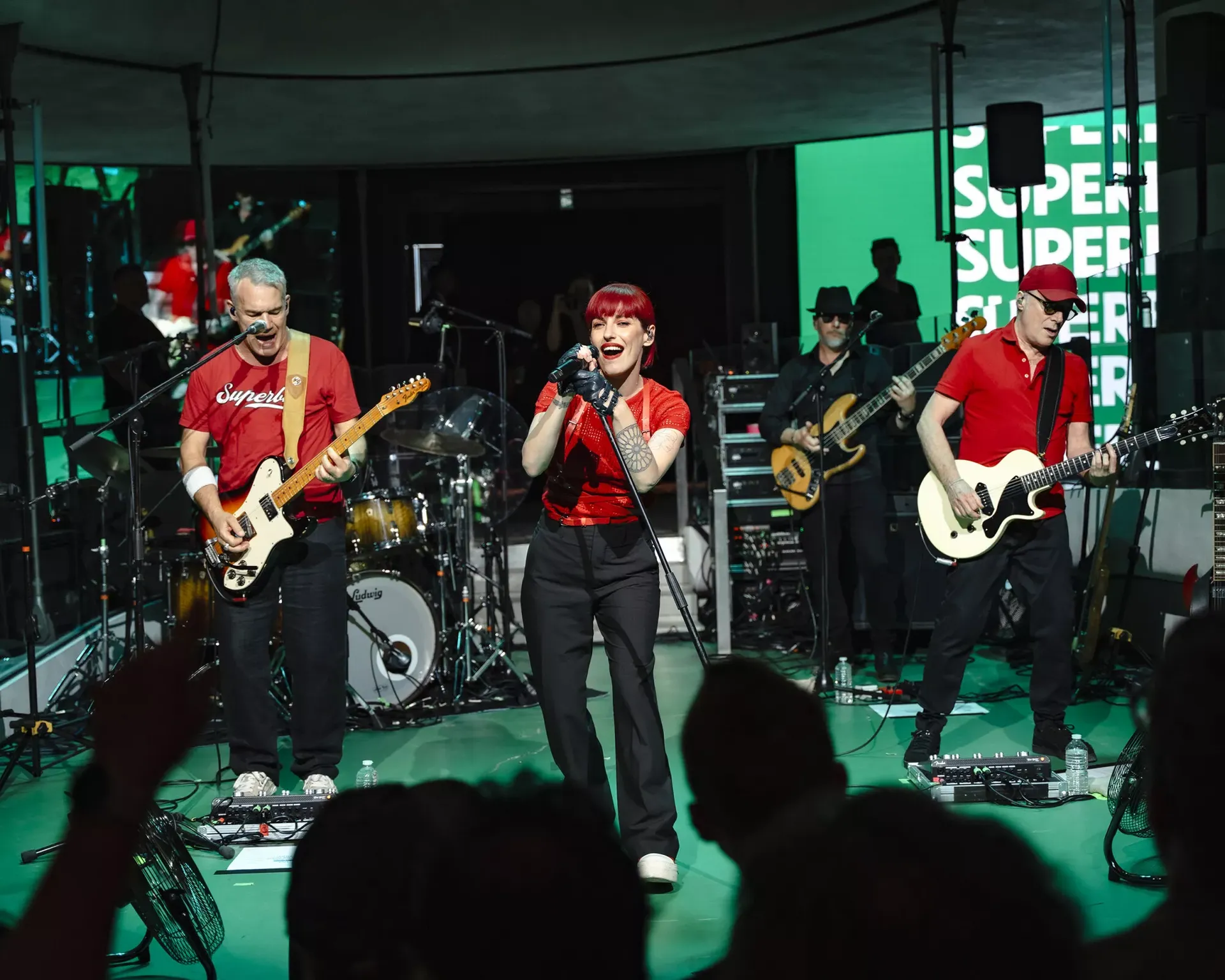 Renault — zespół muzyczny w czerwonych koszulkach grający na gitarach przed publicznością