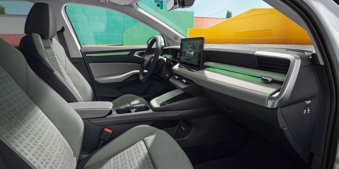 Škoda Epiq — wnętrze od strony pasażera, deska rozdzielcza z ekranem 13 cali, jasna tapicerka z zielonymi akcentami
